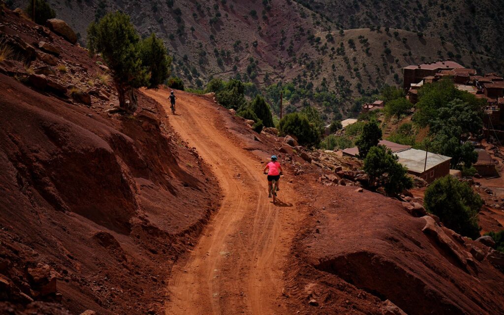 Two people mountain biking through the High Atlas Mountains