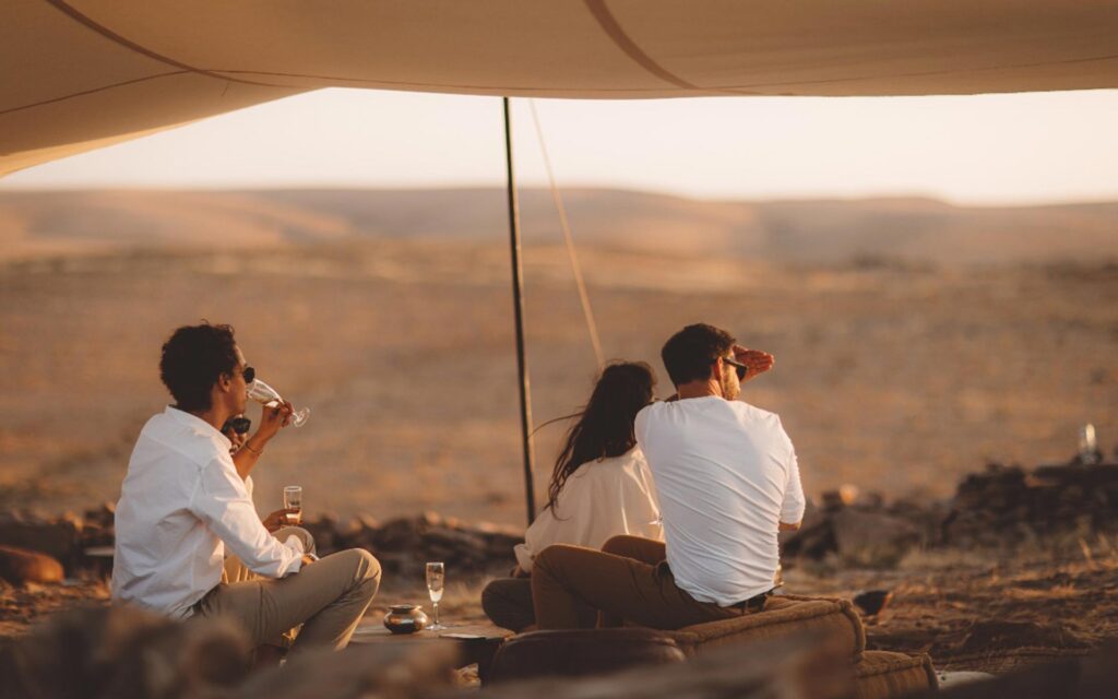 Drinking champagne at sunset at an Agafay Desert Camp